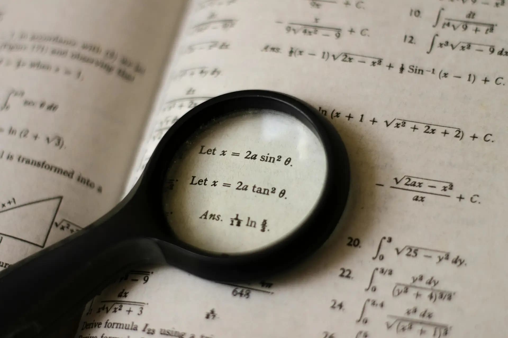 Magnifying glass over mathematics book